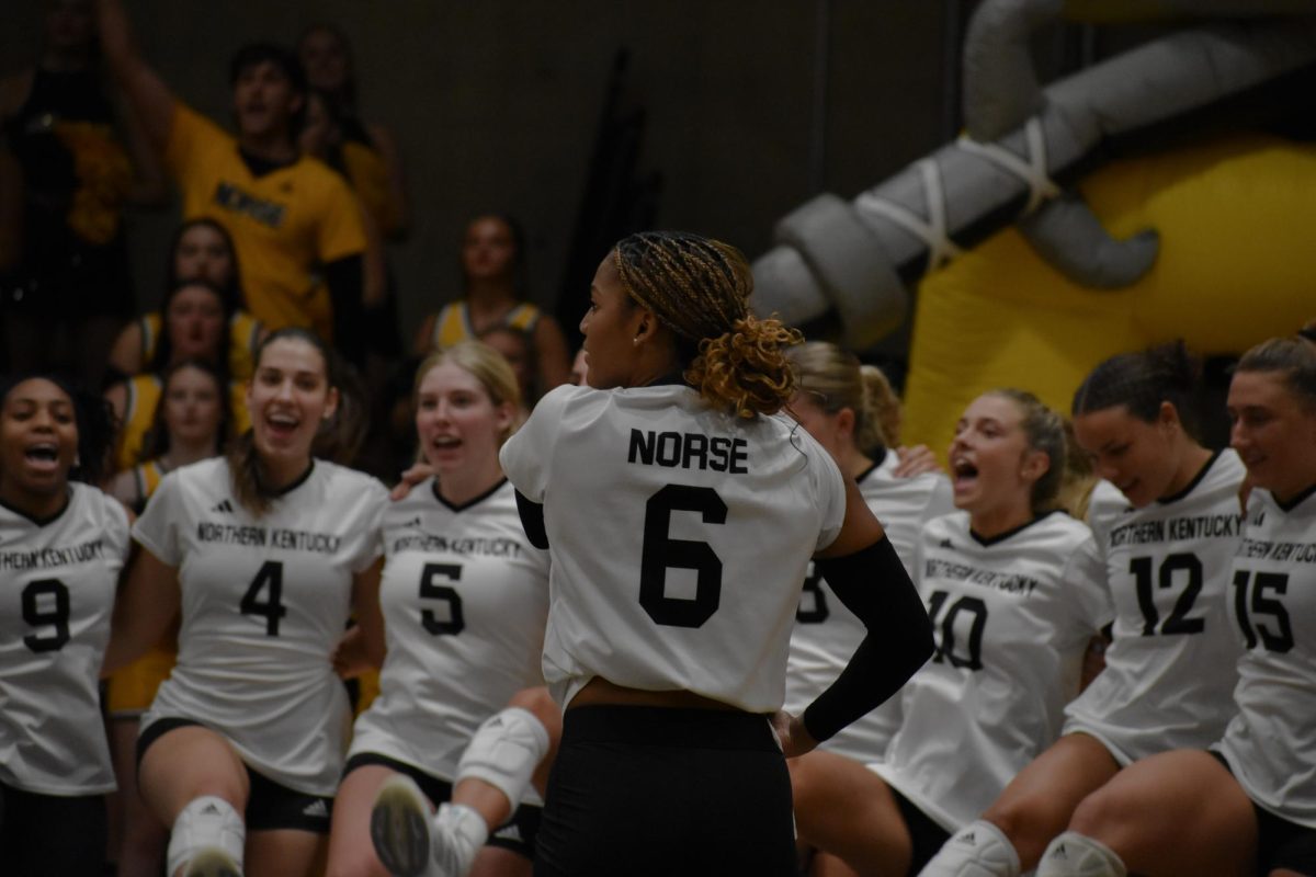 NKU volleyball celebrates a point as Joy Banks sets up to serve against Xavier.