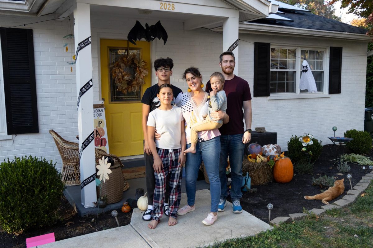 Rachel Paxitzis (middle) poses with her three children and boyfriend in front of her home.