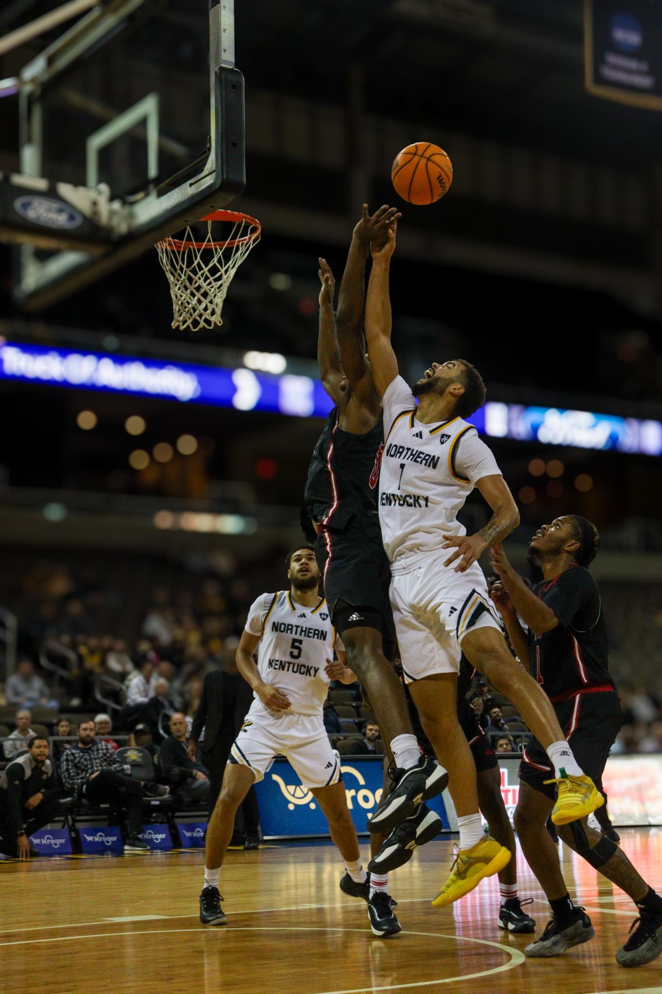 Trey Robinson and Mekhi Collins fighting for a rebound in a physical game.