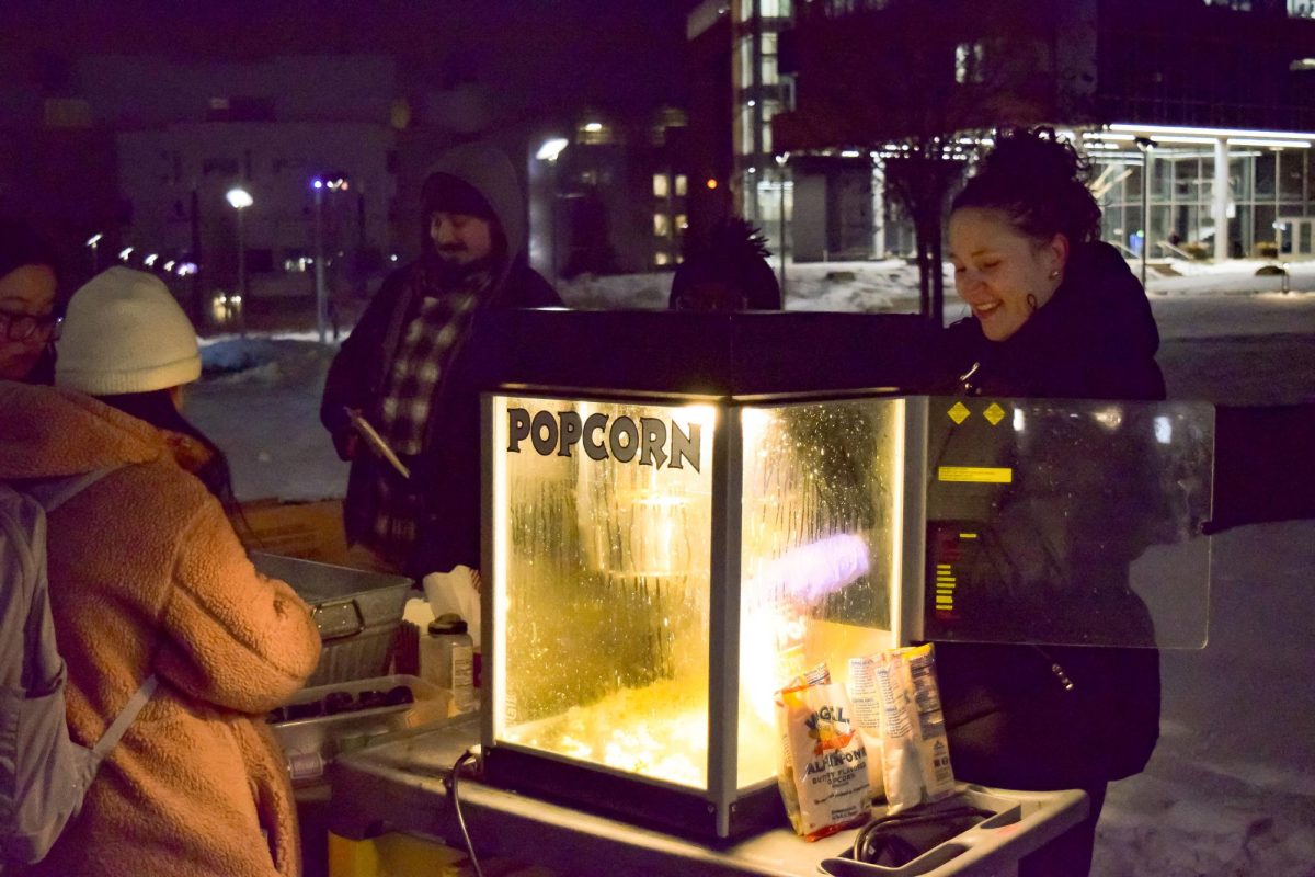 NKU staff members serve popcorn to students during Winterfest.