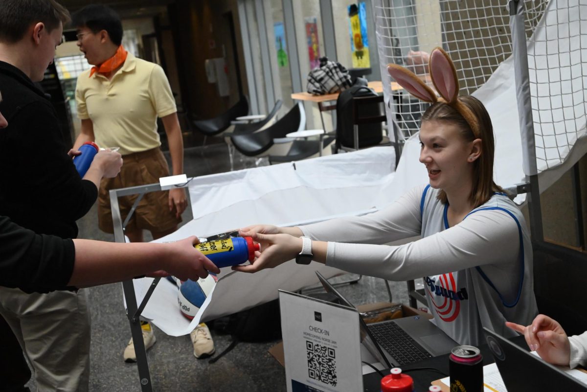 A participant is handed a water bottle and pair of socks.